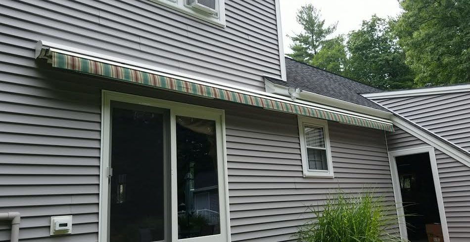 Sunesta retractable awning adds color to a gray house